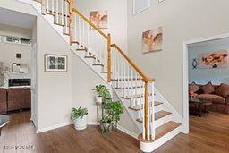 stairs with a high ceiling, baseboards, and wood finished floors