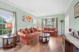 living room with crown molding and wood finished floors