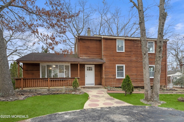 view of front of property featuring a chimney and a front yard