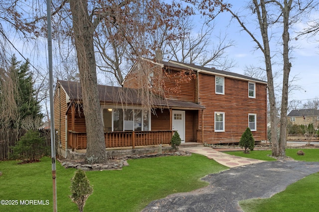 view of front of house featuring covered porch and a front lawn