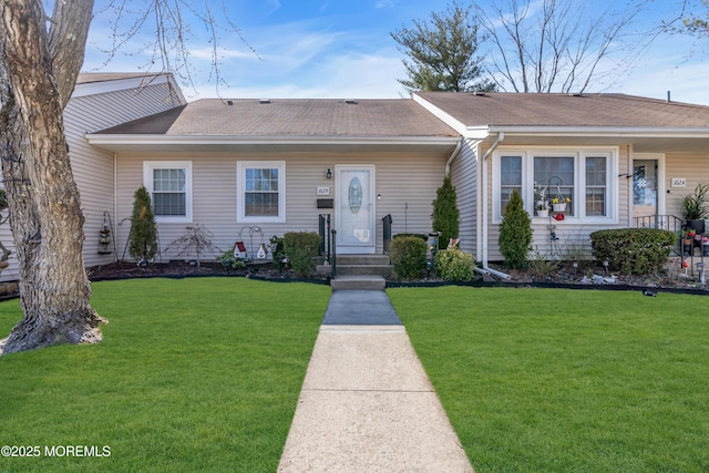 single story home featuring a front lawn and a shingled roof