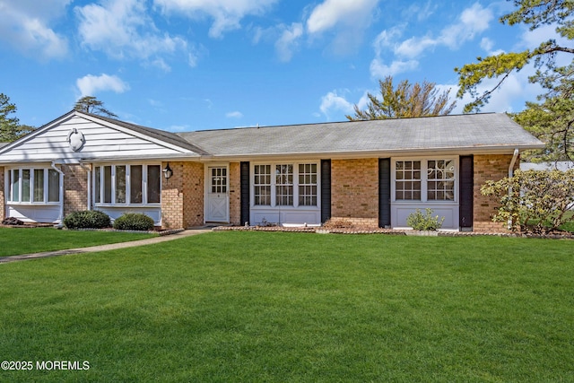 ranch-style house with a front yard and brick siding