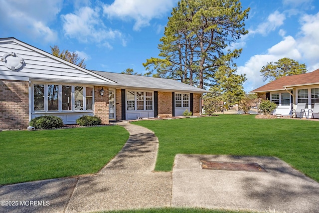 view of front of home with brick siding and a front yard