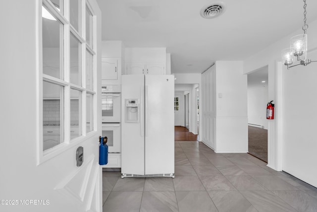 interior space with a notable chandelier, visible vents, and light tile patterned floors