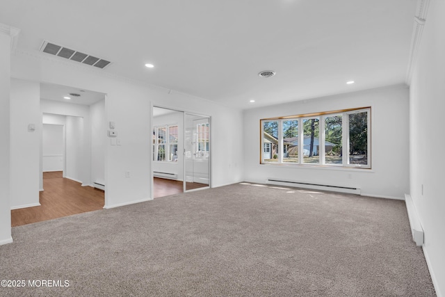 empty room with visible vents, carpet floors, and a baseboard radiator