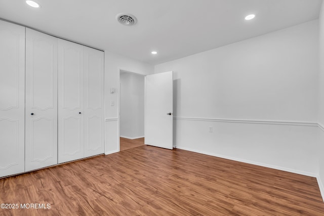 unfurnished bedroom featuring visible vents, wood finished floors, recessed lighting, a closet, and baseboards