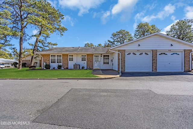 ranch-style house with aphalt driveway, brick siding, a garage, and a front lawn