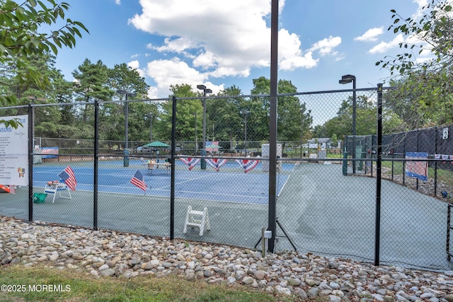 view of tennis court featuring fence