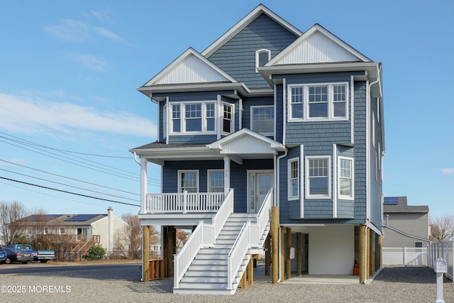 raised beach house with covered porch, fence, and stairs