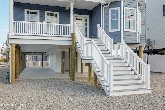 property entrance featuring a carport, a porch, central AC, and driveway