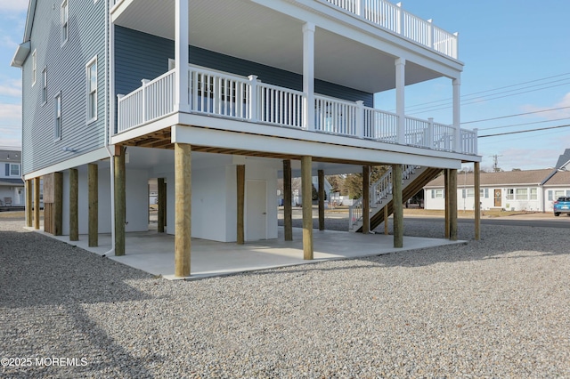 back of property with stairs and a patio area