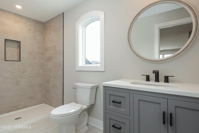 full bath featuring baseboards, tiled shower, toilet, vanity, and recessed lighting