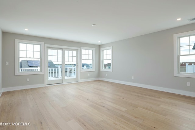 empty room with light wood-style floors, recessed lighting, and baseboards