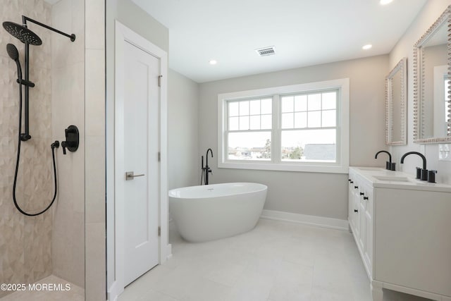 bathroom with visible vents, vanity, baseboards, and tiled shower