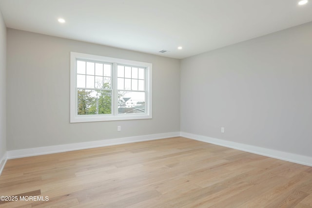 spare room featuring recessed lighting, light wood-style flooring, and baseboards