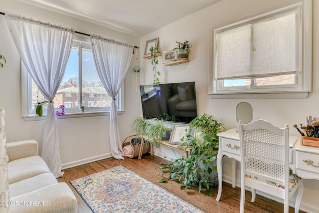 living area featuring baseboards and wood finished floors