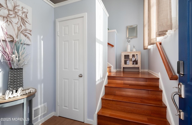 stairs with visible vents, baseboards, and wood finished floors