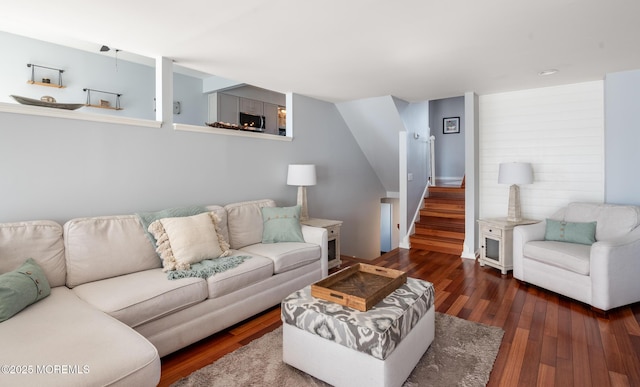 living area featuring stairs, hardwood / wood-style floors, and a fireplace