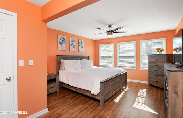 bedroom with ceiling fan, wood finished floors, and baseboards