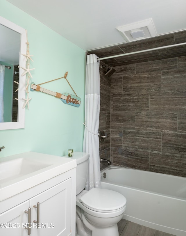 full bath featuring toilet, shower / bath combo with shower curtain, and vanity