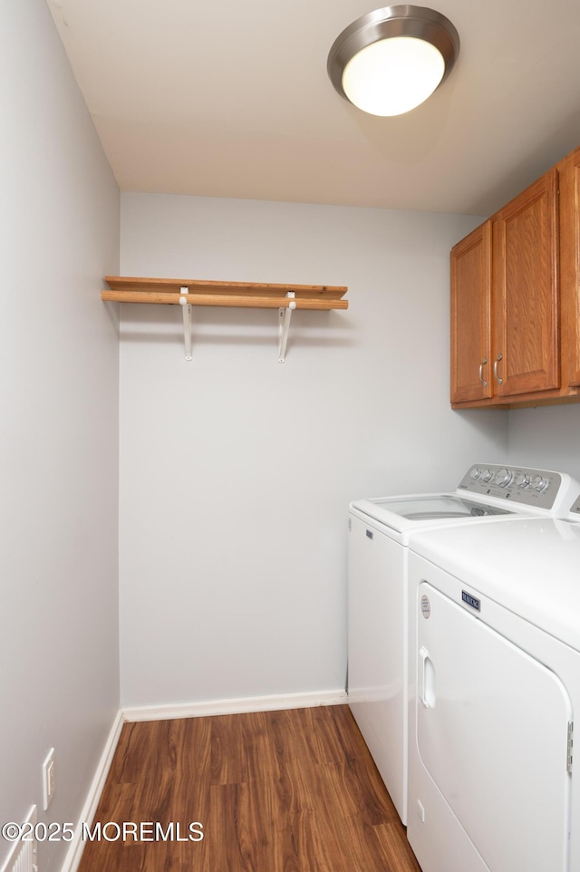 washroom with washer and dryer, cabinet space, dark wood finished floors, and baseboards