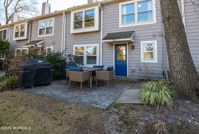 rear view of property with a patio and a chimney