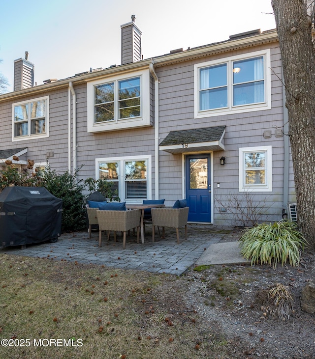 back of property with a patio area and a chimney