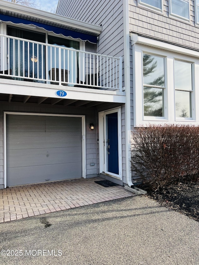 property entrance with decorative driveway and an attached garage
