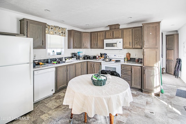 kitchen with ornamental molding, light countertops, white appliances, and stone finish floor