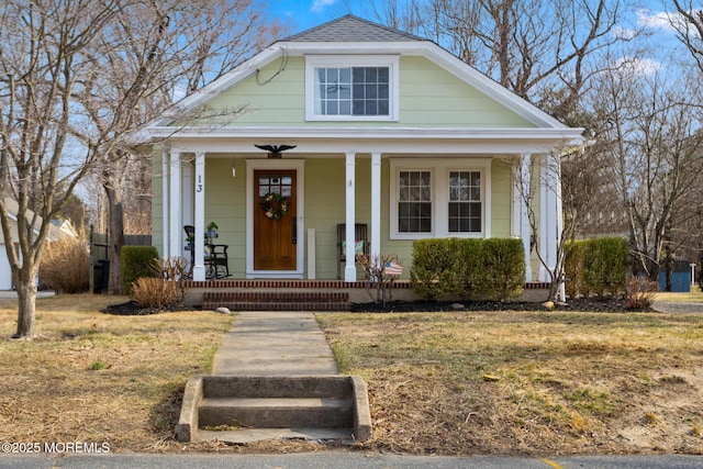 view of front facade featuring covered porch and roof with shingles