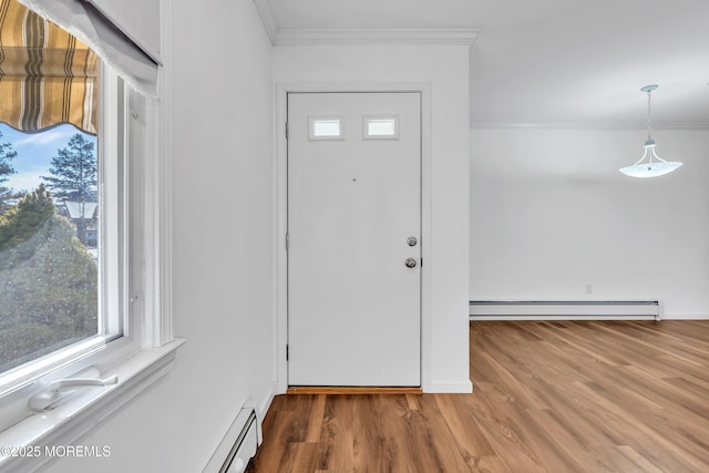 entryway with baseboard heating, crown molding, and wood finished floors