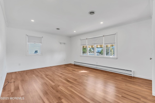 unfurnished room with visible vents, ornamental molding, a baseboard heating unit, light wood finished floors, and baseboards