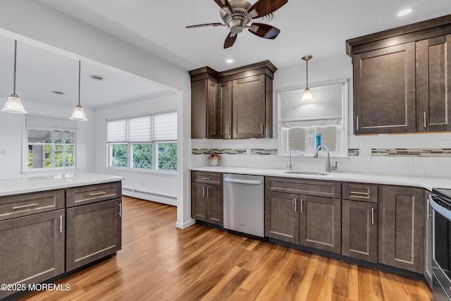 kitchen featuring a sink, stainless steel appliances, dark brown cabinetry, and a baseboard radiator