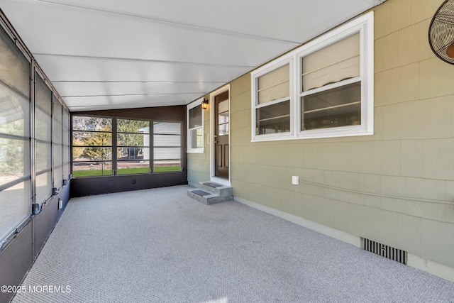 unfurnished sunroom featuring vaulted ceiling and visible vents