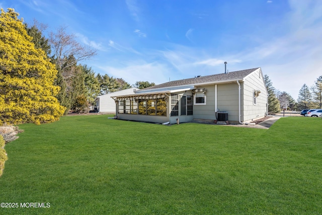 back of property featuring cooling unit, a yard, and a sunroom