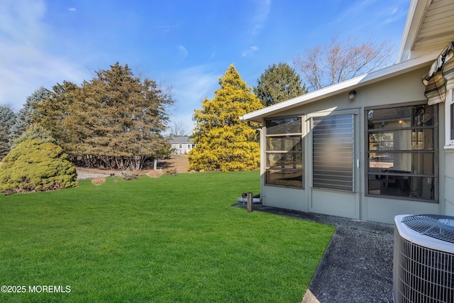 view of yard featuring a sunroom and central AC