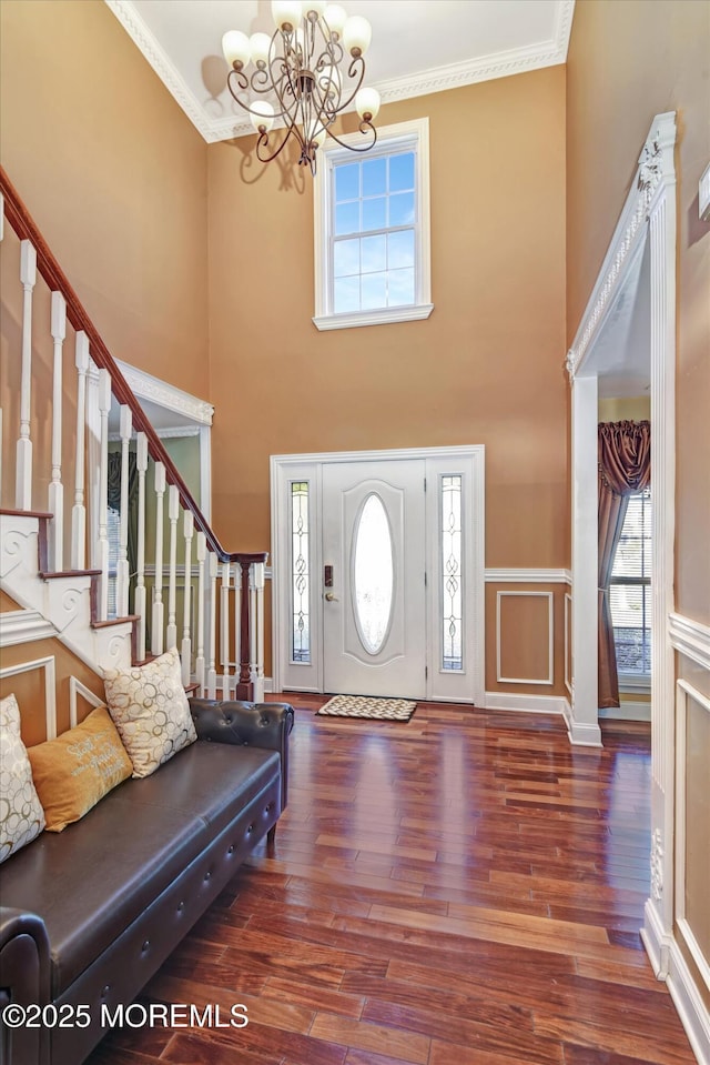 entrance foyer featuring ornamental molding, stairway, and wood finished floors