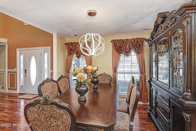 dining area featuring a wealth of natural light, dark wood-style flooring, visible vents, and an inviting chandelier