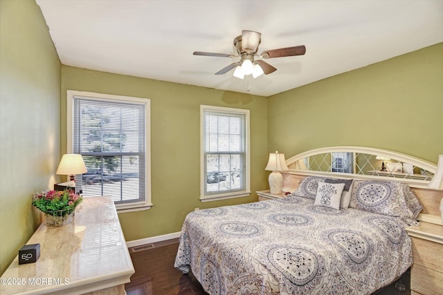 bedroom with visible vents, dark wood finished floors, baseboards, and ceiling fan