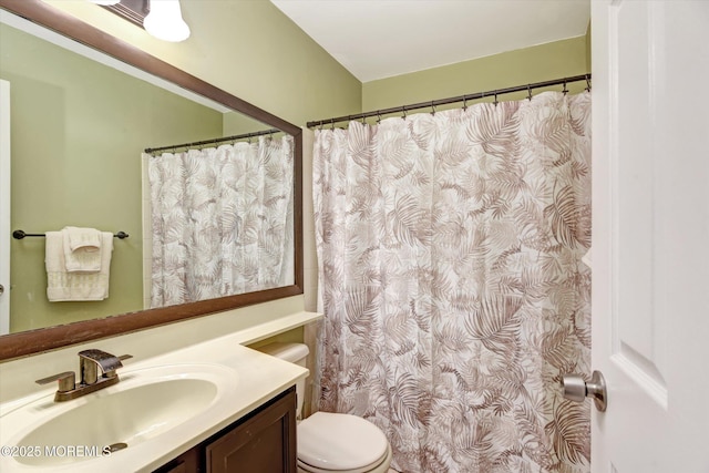 full bath with curtained shower, vanity, and toilet