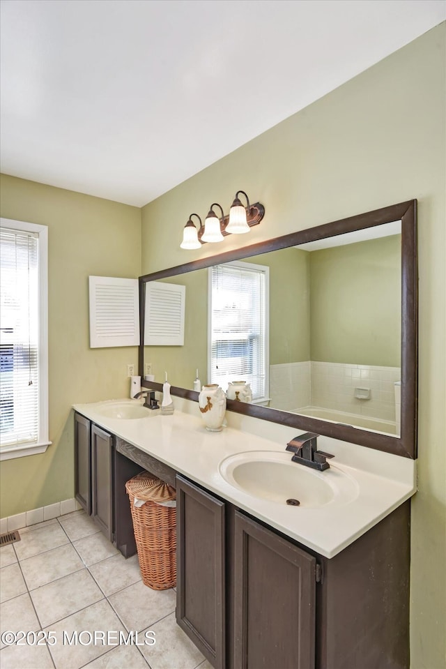 bathroom featuring tile patterned flooring, a sink, baseboards, and double vanity