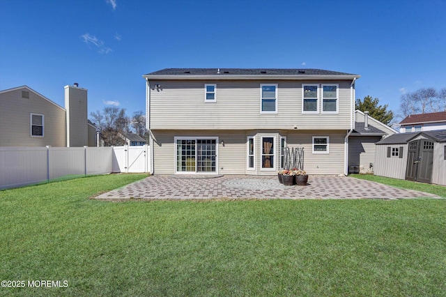 back of house featuring an outbuilding, a fenced backyard, a patio, and a storage shed