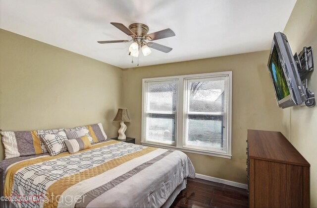 bedroom featuring dark wood-type flooring, ceiling fan, and baseboards