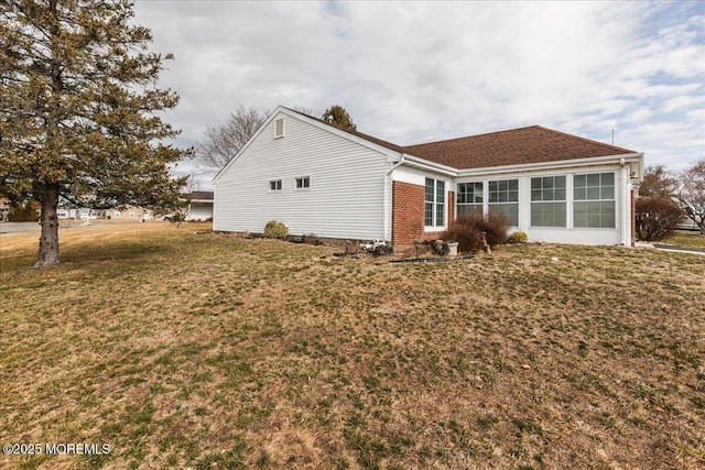 exterior space featuring brick siding and a lawn