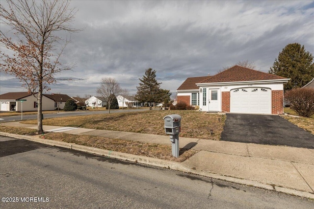 view of front facade with an attached garage, a residential view, aphalt driveway, and brick siding