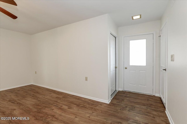 interior space featuring dark wood-style floors, ceiling fan, and baseboards