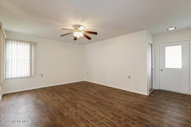 empty room with a ceiling fan, dark wood-style flooring, and baseboards