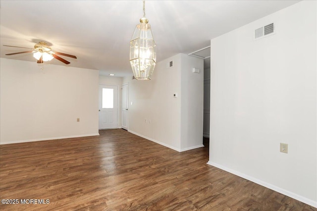 unfurnished room with dark wood-style flooring, visible vents, and baseboards