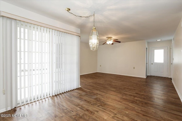 unfurnished room featuring baseboards, a ceiling fan, and wood finished floors