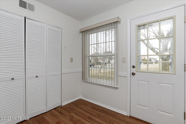 doorway to outside with baseboards, visible vents, and dark wood finished floors